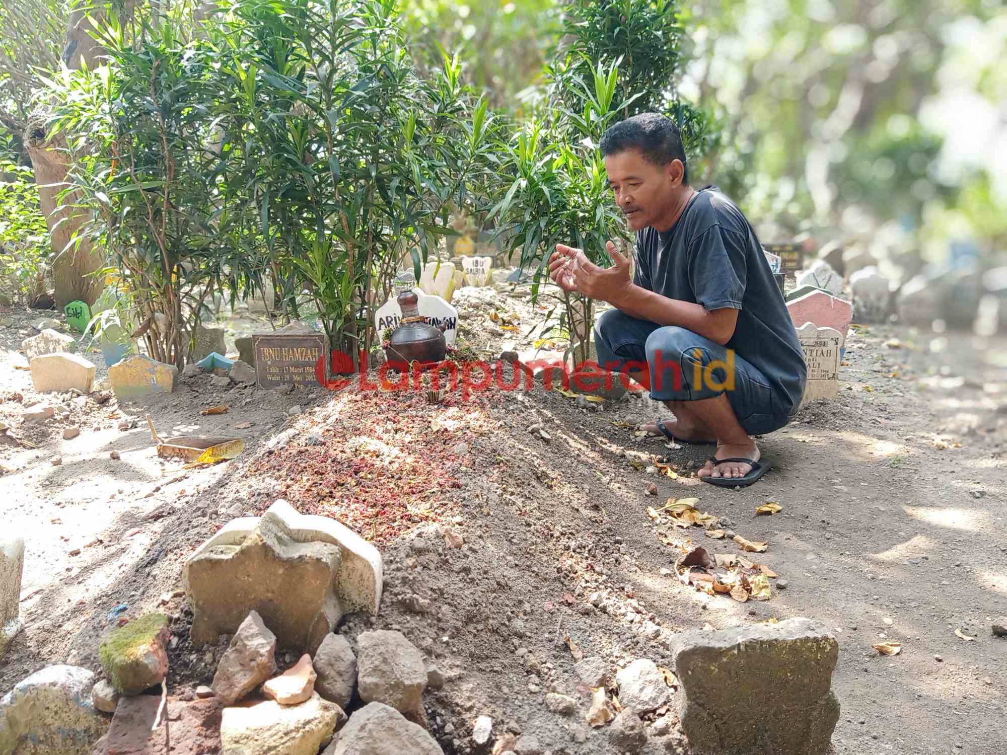 Teks foto : Mat Shocib saat berdoa di makam Arik Setiawan