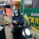 Tertangkap kamera wartawan. Sebagai bentuk apresiasi, seorang pemudik pengendara sepeda motor memberikan minuman mineral dan roti kepada petugas lalu lintas Polres Serang yang sedang mengatur arus lalu lintas dibawah terik matahari. (Foto : Daeng Yus)